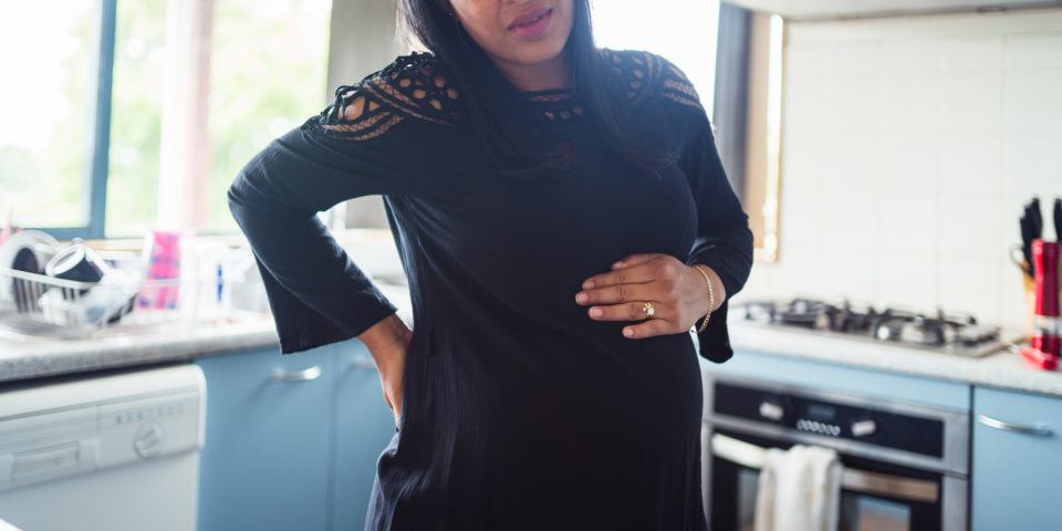 Woman having back pain because of pregnancy.